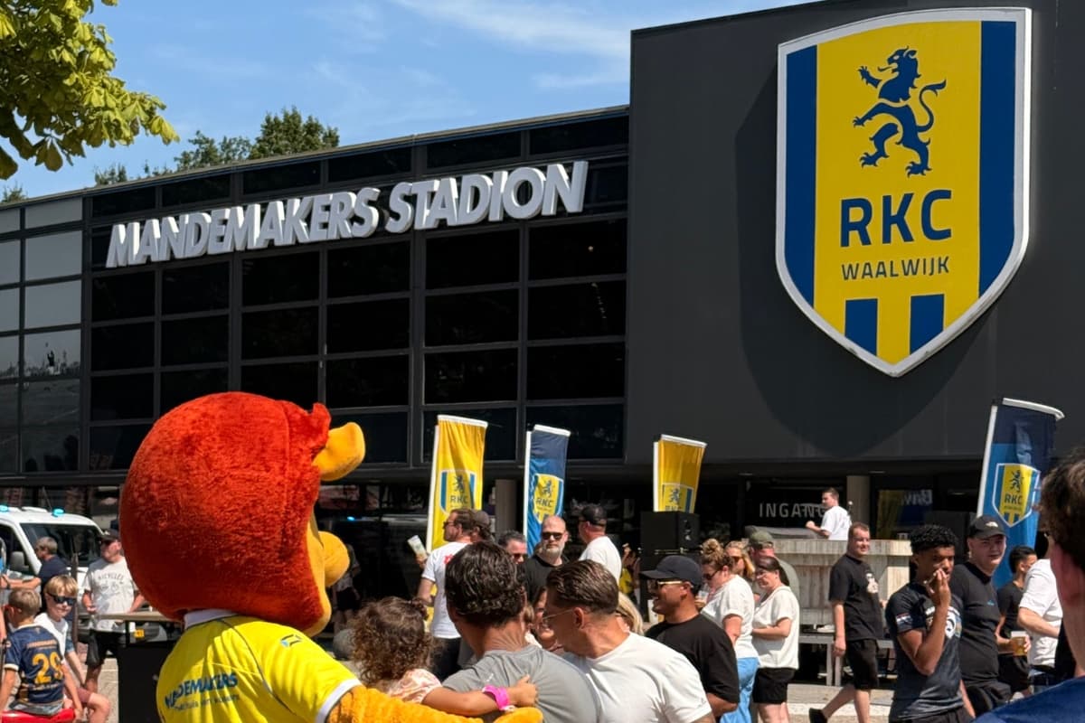 Foto waar mensen een persoon verkleed als een leeuw voor het RKC stadion staan