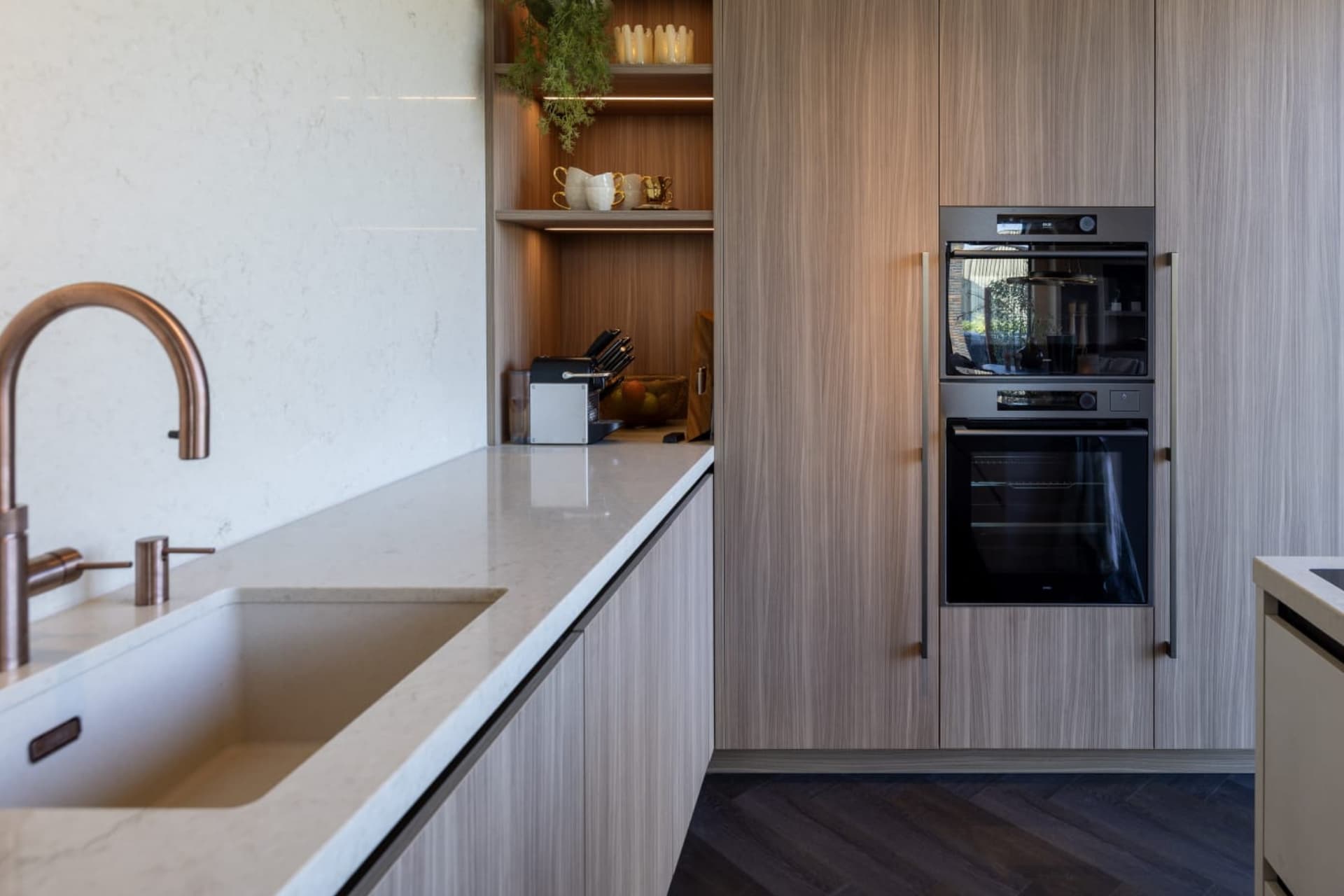 header image.jpg Houten hoekkeuken met hoge kasten en een kookeiland