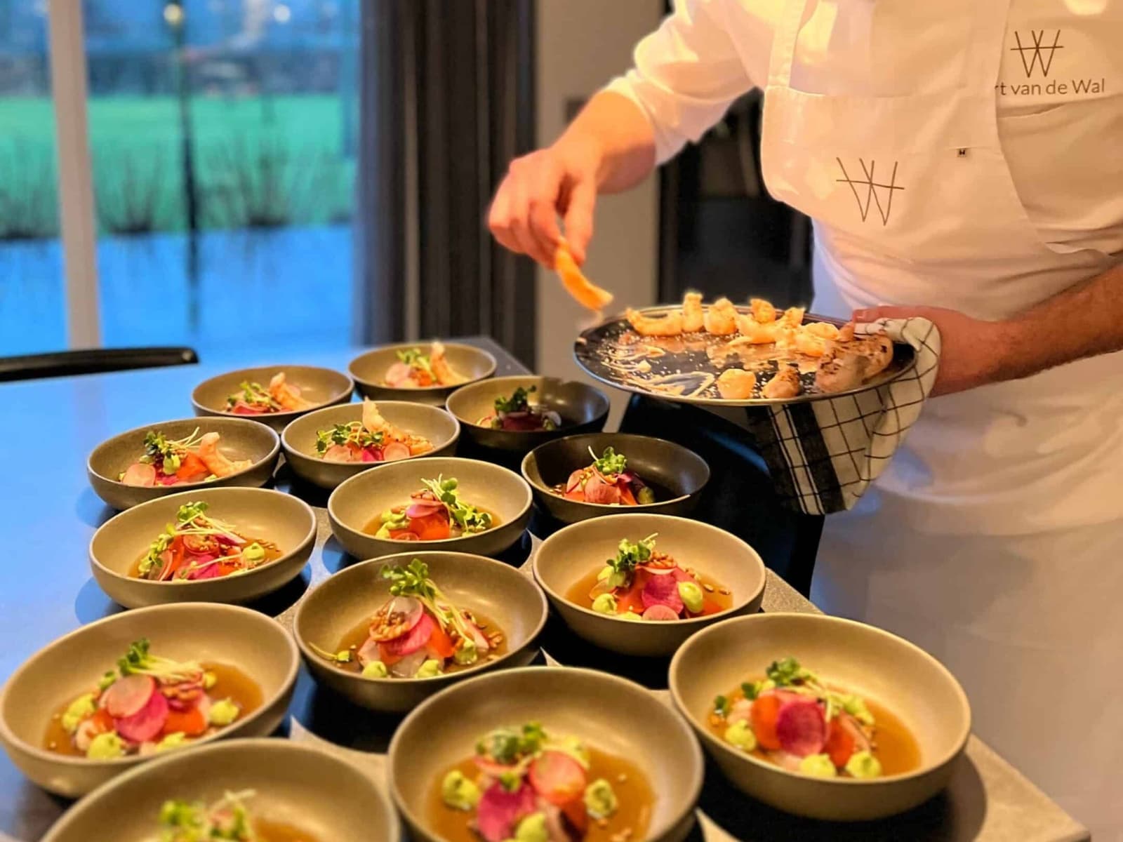winactie-private-dining.jpg Kok die eten opschept op een rij van borden