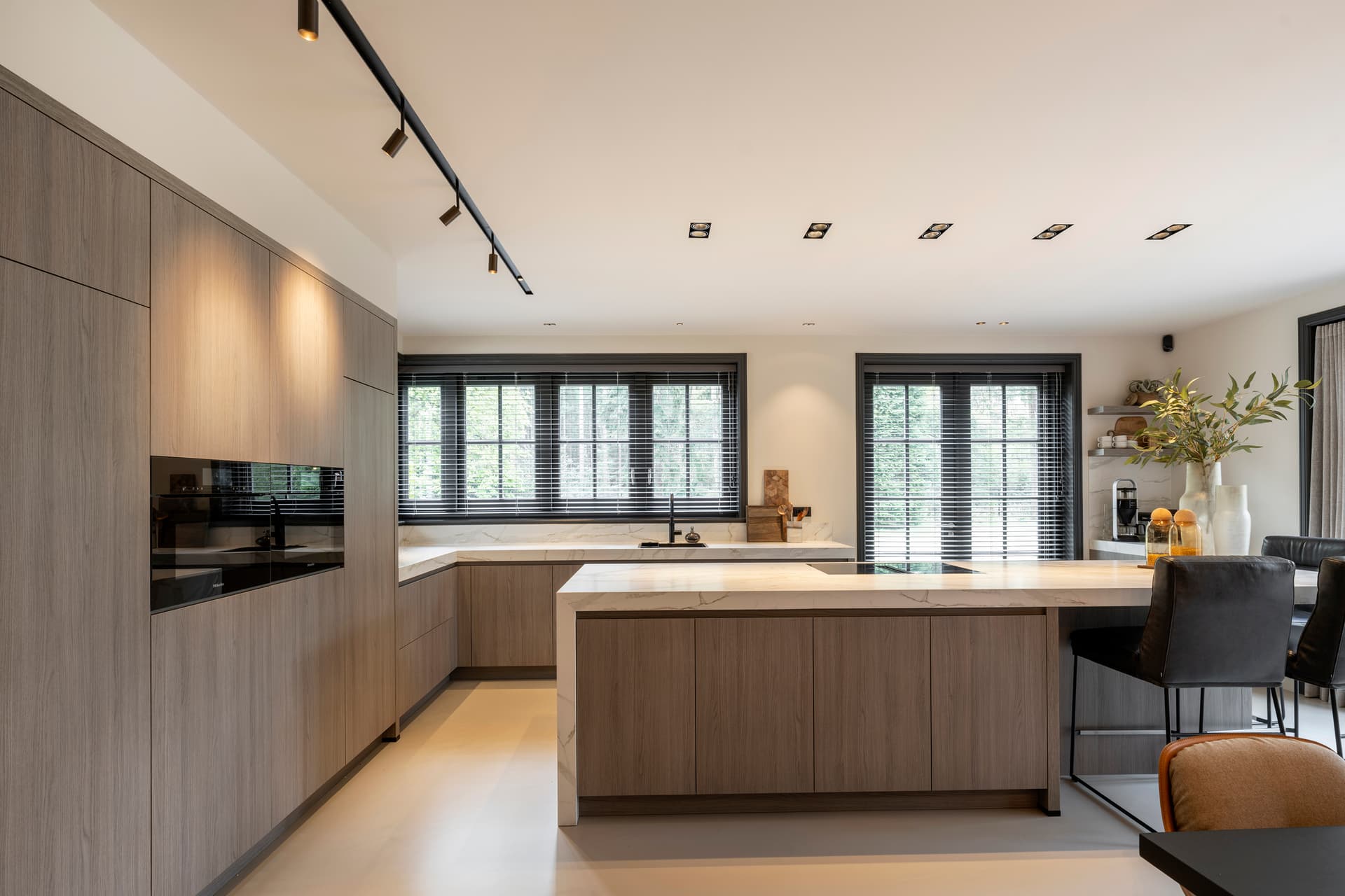 Licht houten eilandkeuken met bar en Dekton werkblad
